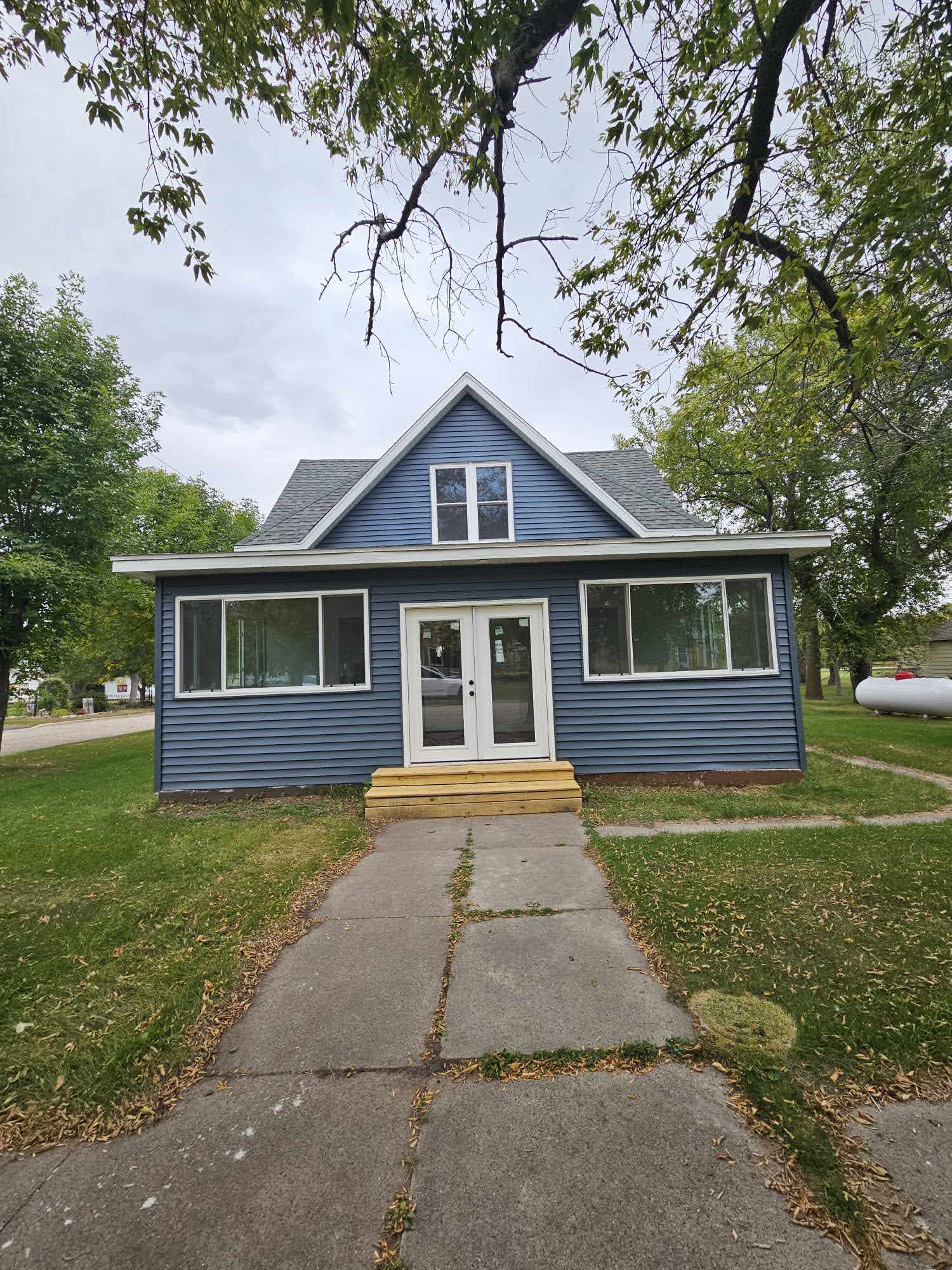 Front exterior of 103 Sheyenne Street with blue siding and new windows